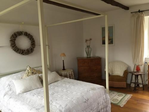 a bedroom with a canopy bed and a dresser at Le Couvent in Saint-Just-sur-Viaur
