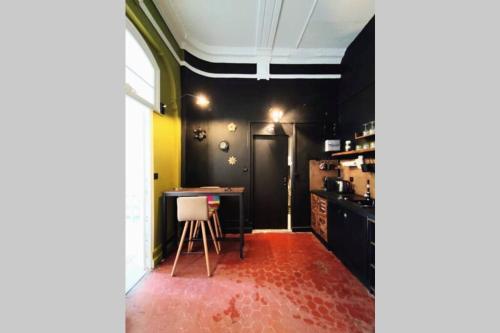 une cuisine avec des armoires noires et un tapis rouge dans l'établissement Le Saint du Vieux Port, à Marseille