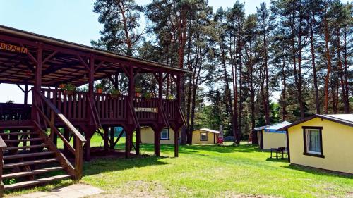 eine große Holzterrasse in einem Hof neben einigen Campingplätzen in der Unterkunft Stanica Wodna Spychowo in Spychowo