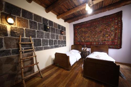 a room with two beds and a brick wall at Alashkert Guesthouse ,Ալաշկերտ Հյուրատուն in Gyumri
