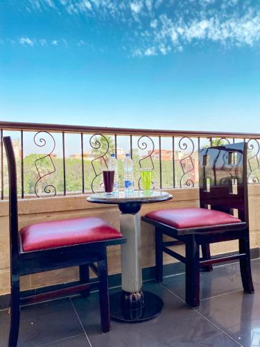 a table and two chairs sitting on a balcony at Best View Pyramids Hotel in Cairo