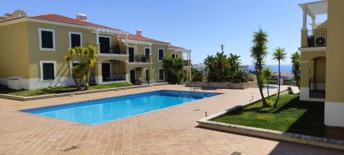 a villa with a swimming pool in front of a house at 5B Sra da Rocha - Casas & Papeis in Armação de Pêra