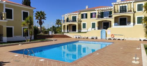 a swimming pool in front of a building at 5B Sra da Rocha - Casas & Papeis in Armação de Pêra