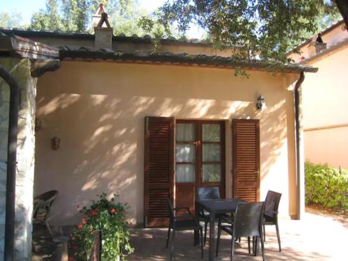 a table and chairs in front of a house at Appartamento Il Leccio Pian delle more in Sassetta