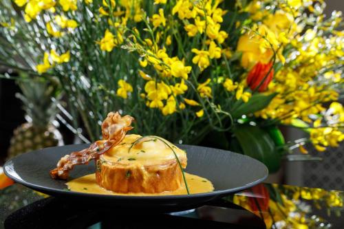 a plate with a piece of food on a table with flowers at Heritage hotel Santa Lucia in Split