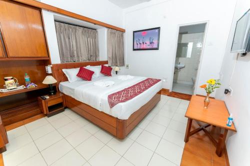 een slaapkamer met een groot bed en een badkamer bij Hotel Green Field in Satara