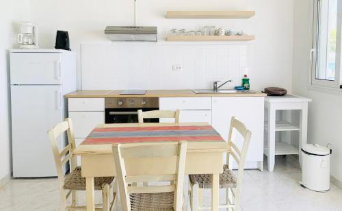 a kitchen with a table and chairs and a sink at Seaside Bungalows Petalidi in Petalidhion
