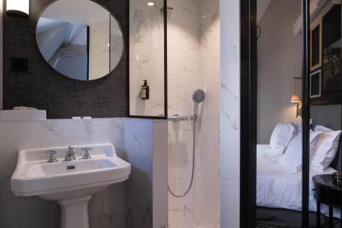 a bathroom with a sink and a mirror at Les Demeures de Varennes, BW Signature Collection in Varennes-Jarcy