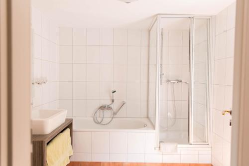 ein Badezimmer mit Dusche, Badewanne und Waschbecken in der Unterkunft Altstadt Hotel Glockenhof in Eltville