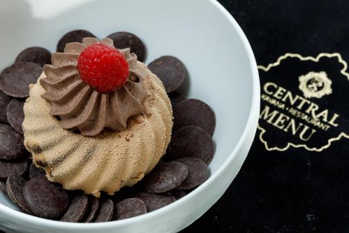 a cupcake with a raspberry on top of chocolate chips at Heritage hotel Santa Lucia in Split
