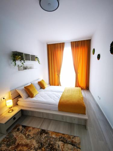 a bedroom with a large bed with orange curtains at Karra Residence Timisoara - autorizat Ministerul Turismului in Timişoara