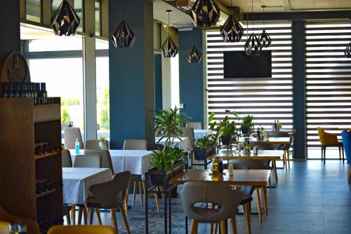 a restaurant with tables and chairs and a flat screen tv at Vila Europa in Struga