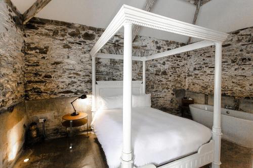 a bedroom with a white bed and a bath tub at ANRÁN at Tidwell Farm in Staverton