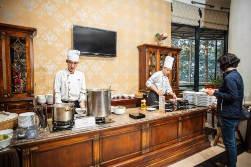 twee koks staan in een keuken eten te bereiden bij Dalat Edensee Lake Resort & Spa in Da Lat