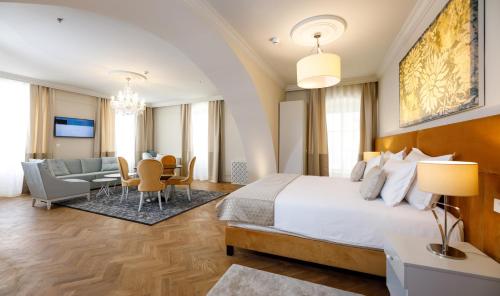 a bedroom with a large bed and a living room at Heritage hotel Santa Lucia in Split
