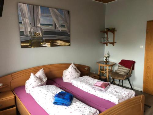 a room with two beds and a table at Hotel & Restaurant Neptun in Norddorf