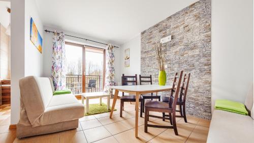 - une cuisine et une salle à manger avec une table et des chaises dans l'établissement Apartamenty Sun & Snow Mierzeja Park, à Sztutowo