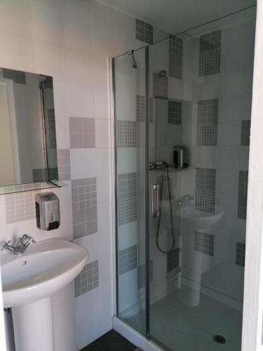 a bathroom with a glass shower and a sink at Day Off Suite&Hostel in Setúbal