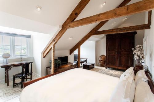 a bedroom with a large bed and a desk at ANRÁN at Tidwell Farm in Staverton