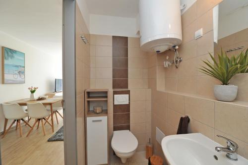 a bathroom with a toilet and a sink and a table at BELLAPARTMAN in Balatonfüred