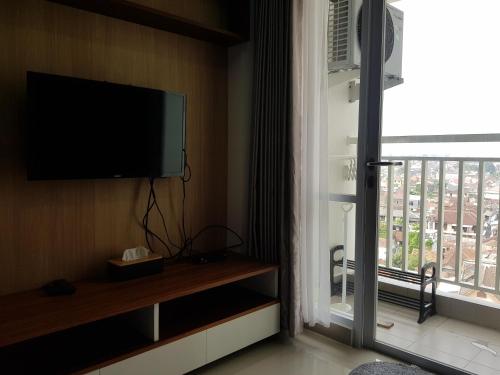 Habitación con TV de pantalla plana y ventana. en Apartemen Taman Melati Sinduadi 60, en Yogyakarta
