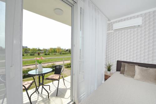 a bedroom with a bed and a balcony with a table at Bella Donna in Balatonfüred