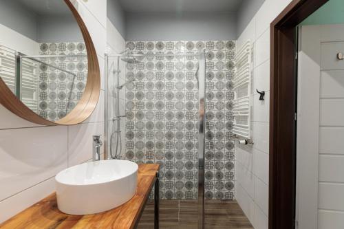 La salle de bains est pourvue d'un lavabo et d'une douche. dans l'établissement Golden Apartments Wroclaw&K24, à Wrocław