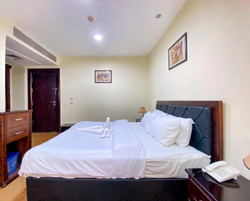 a bedroom with a large white bed with a telephone at Best View Pyramids Hotel in Cairo