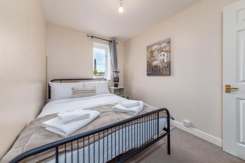 a bedroom with a bed with two towels on it at Suites by Rehoboth - 23 Thames View - Upper - Woolwich in London