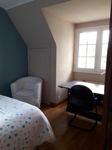 a bedroom with a bed and a desk and a chair at Chambre dans villa in Gouesnou