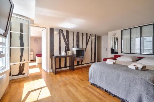 - une chambre avec un lit et une télévision dans l'établissement The Perfect Parisian 2 bdrs flat at Le Marais, à Paris