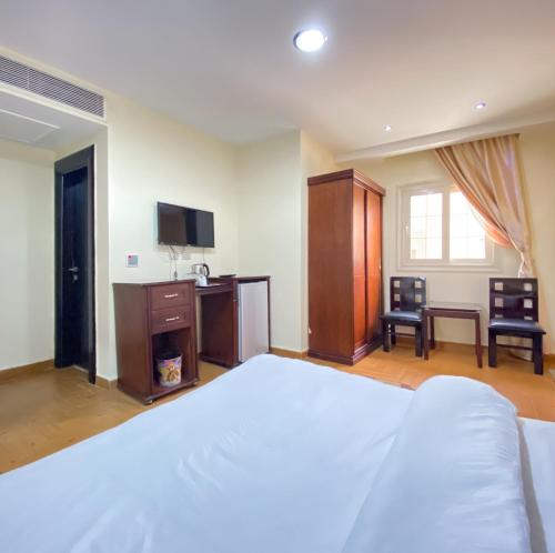 a bedroom with a bed and a desk and a tv at Best View Pyramids Hotel in Cairo