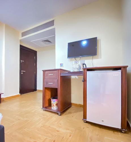 a room with a desk with a tv on a wall at Best View Pyramids Hotel in Cairo