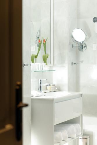 a white bathroom with a sink and a mirror at Heritage hotel Santa Lucia in Split