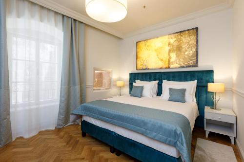 a bedroom with a blue and white bed and a window at Heritage hotel Santa Lucia in Split