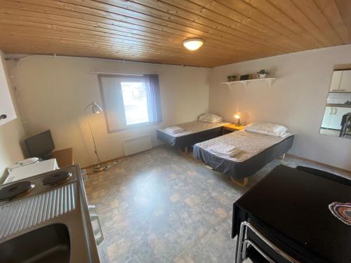 an empty room with two beds and a window at Economy Apartments Peura in Rovaniemi