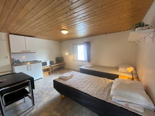 a small room with two beds and a kitchen at Economy Apartments Peura in Rovaniemi