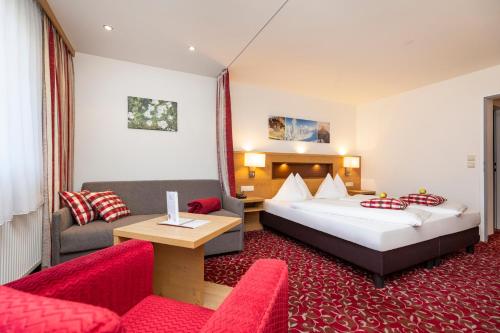 pokój hotelowy z 2 łóżkami i kanapą w obiekcie Hotel Pongauerhof w mieście Flachau