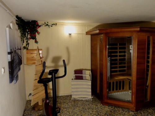a room with a wooden cabinet and a chair at La demeure aux Pins in Lourdes