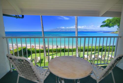 a balcony with a table and chairs and the ocean at Napili Sunset Beach Front Resort in Lahaina