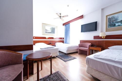 a hotel room with a bed and a living room at Löwen Hotel in Offenbach