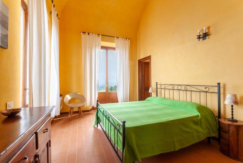 una camera da letto con un letto e una grande finestra di Castello di Populonia VILLA A MARE a Populonia