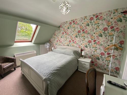 a bedroom with a bed and floral wallpaper at Broom Hall Country Hotel in Saham Toney