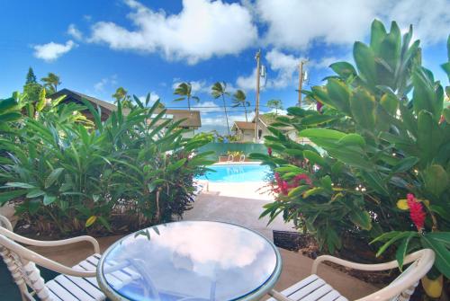 a patio with a table and chairs and a pool at Napili Sunset Beach Front Resort in Lahaina