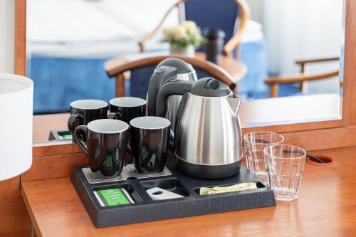 a tea kettle and cups on a tray on a table at Marina in Międzyzdroje