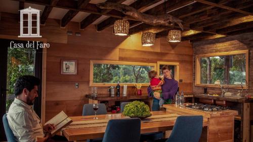 a woman holding a child in a kitchen with a table at Casa del Faro Chiloé in Castro