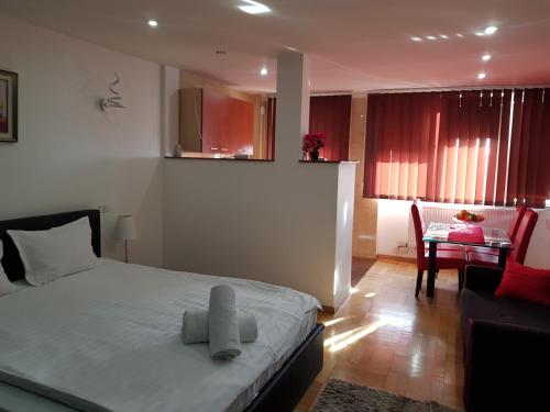 een slaapkamer met een bed en een woonkamer met een tafel bij Apartament Gomoiu Monza Arena Nationala in Boekarest