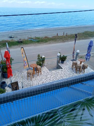 a view of a swimming pool with chairs and a beach at AGATHA appartments PALIOURIA in Kókkinon Nerón