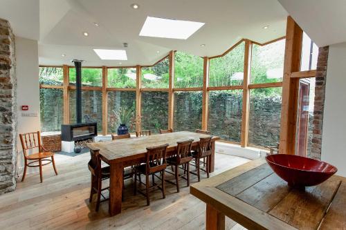 a dining room with a table and chairs and windows at ANRÁN at Tidwell Farm in Staverton