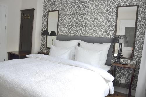 a bedroom with a white bed and two mirrors at Willa Sepia SPA in Wisła